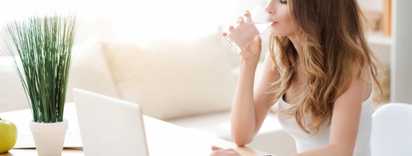 skin hydration - woman drinking a glass of water