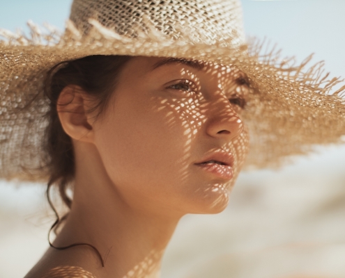 beauty collective - treat dark spots - woman under the sun wearing a native hat