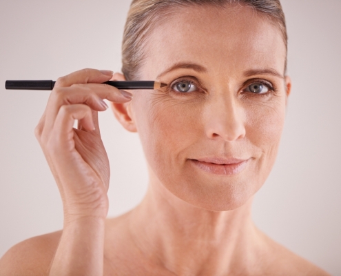 middle aged woman applying eyeliner
