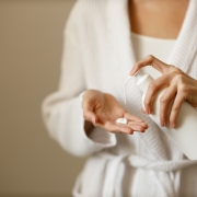 Young,Woman,In,White,Housecoat,Pours,Lotion,Or,Hand,Moisturizer