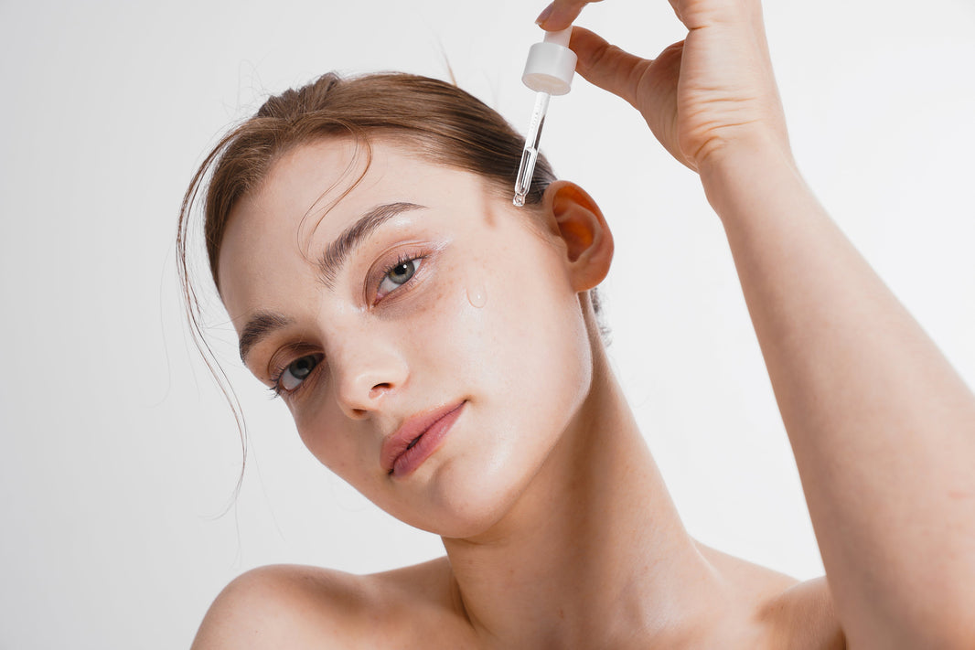 Woman applying skincare serum with dropper for brighter, refreshed under-eye area