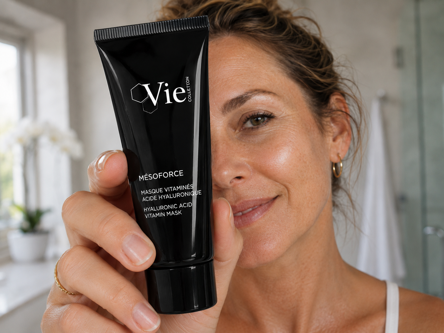 a middle aged woman holding a Vie Collection Vitamin Mask