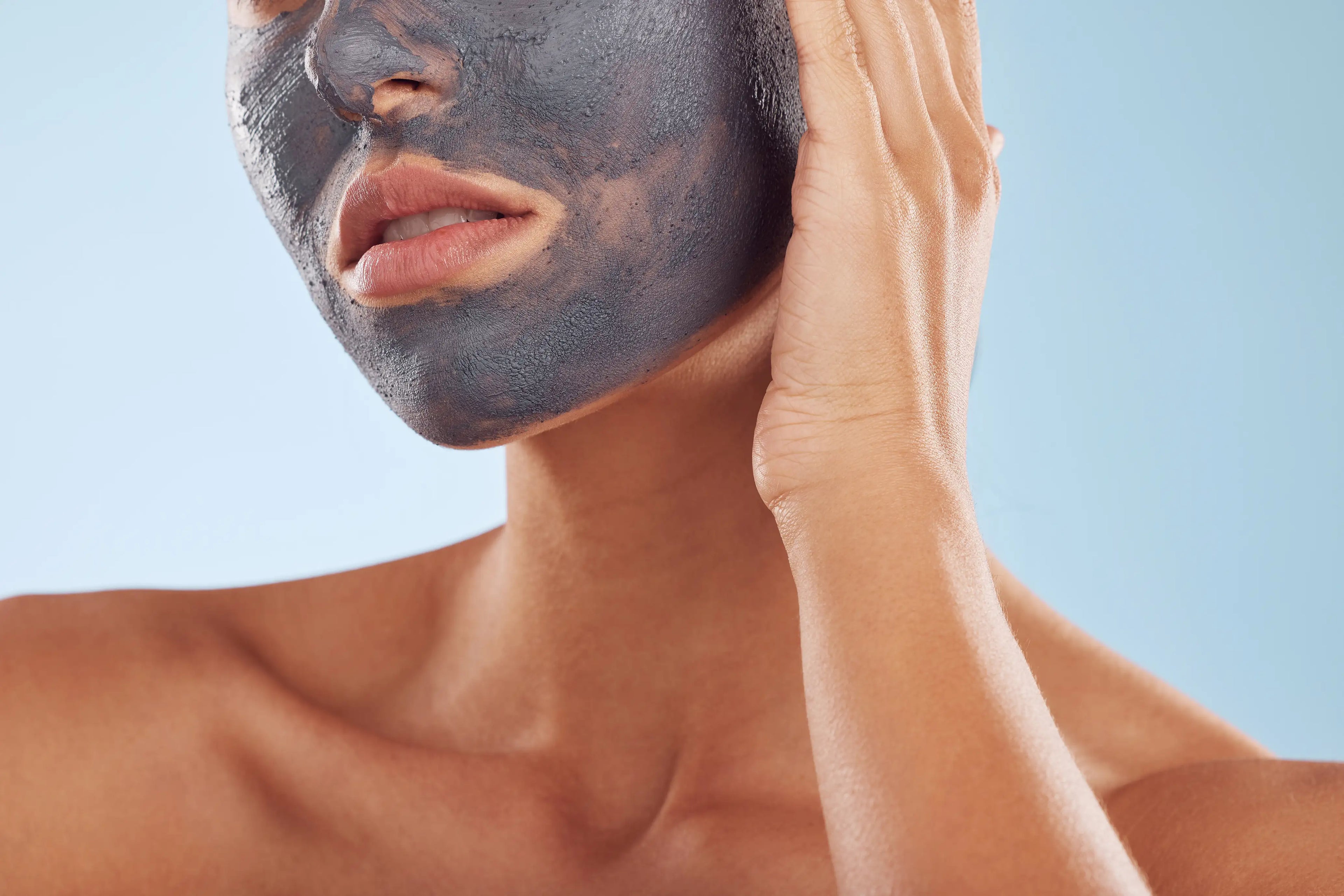 woman with charcoal mask on her face