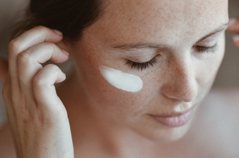 woman has cream on her cheek