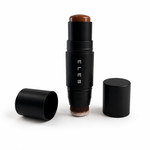 An ELES makeup stick with a black cylindrical body, shown open with the brush exposed and a brown cosmetic product visible at the top. A second black cap lies on the left, and another closed cap stands on the right, all on a clean white background.