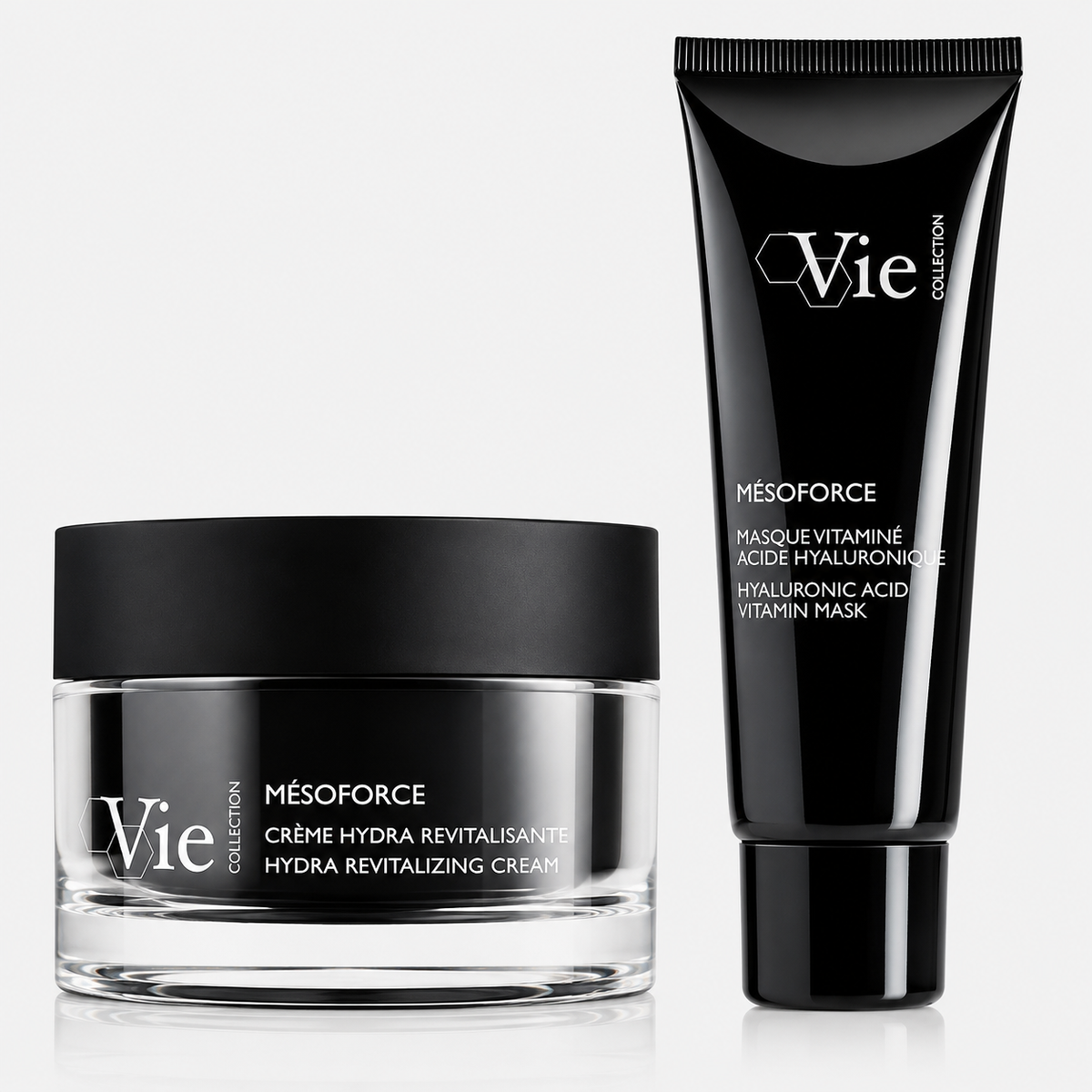 Two Vie Collection skincare products from the Mésoforce range displayed on a light grey background: a clear glass jar of Hydra Revitalizing Cream with a matte black lid beside a black tube of Hyaluronic Acid Vitamin Mask.