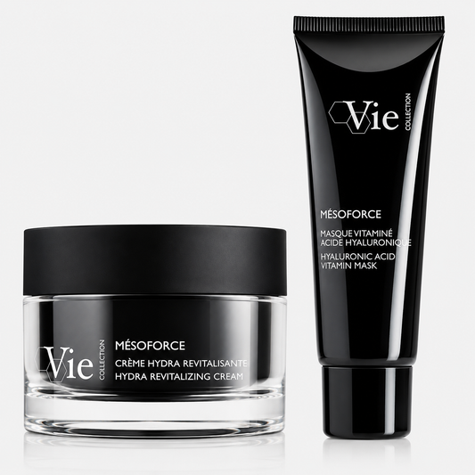 Two Vie Collection skincare products from the Mésoforce range displayed on a light grey background: a clear glass jar of Hydra Revitalizing Cream with a matte black lid beside a black tube of Hyaluronic Acid Vitamin Mask.