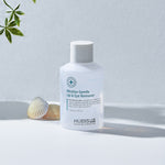 Bottle of Hubislab_pure_balance Micellar Gentle Lip & Eye Remover on a light background with a shell and plant.