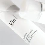 Close-up of a skincare product labeled 'Vie' on a light gray background