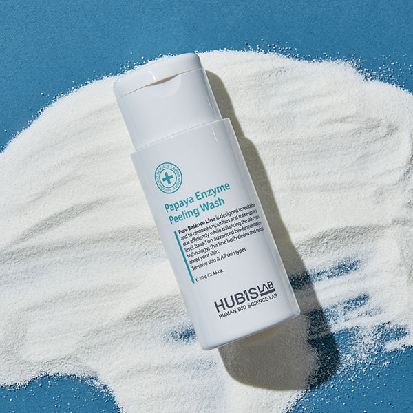 Hubislab Papaya Enzyme Peeling Wash bottle on a textured white surface with blue background