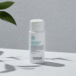 Hubislab Papaya Enzyme Peeling Wash bottle on a gray background with green leaves.