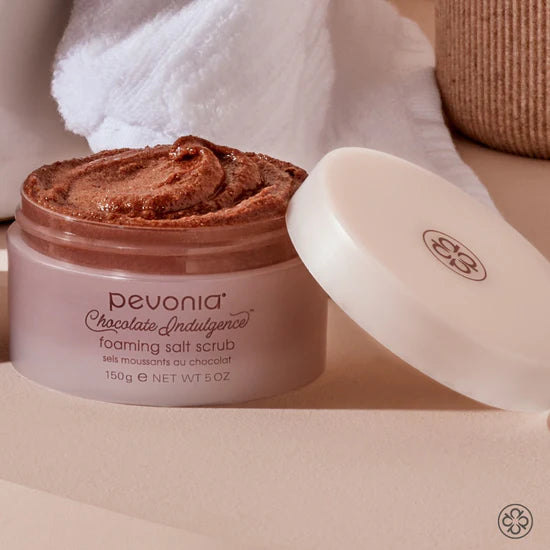 Pevonia Chocolate Indulgence foaming salt scrub with a white spatula on a beige background
