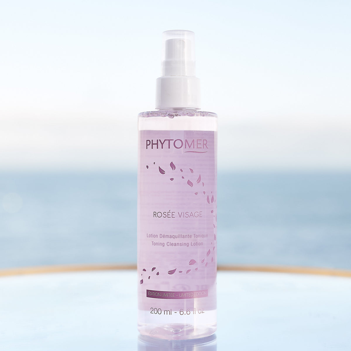 phytomer rosee visage toning cleansing lotion mist limited edition on a reflective surface with a blurred background