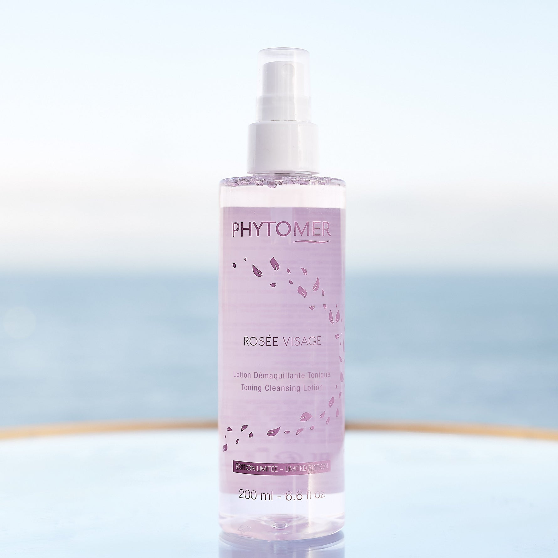 phytomer rosee visage toning cleansing lotion mist limited edition on a reflective surface with a blurred background