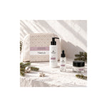 Naturys cleanser, peptide serum, rich cream and white cosmetics bag in a sunlit Christmas setting with pine sprigs and ornaments.