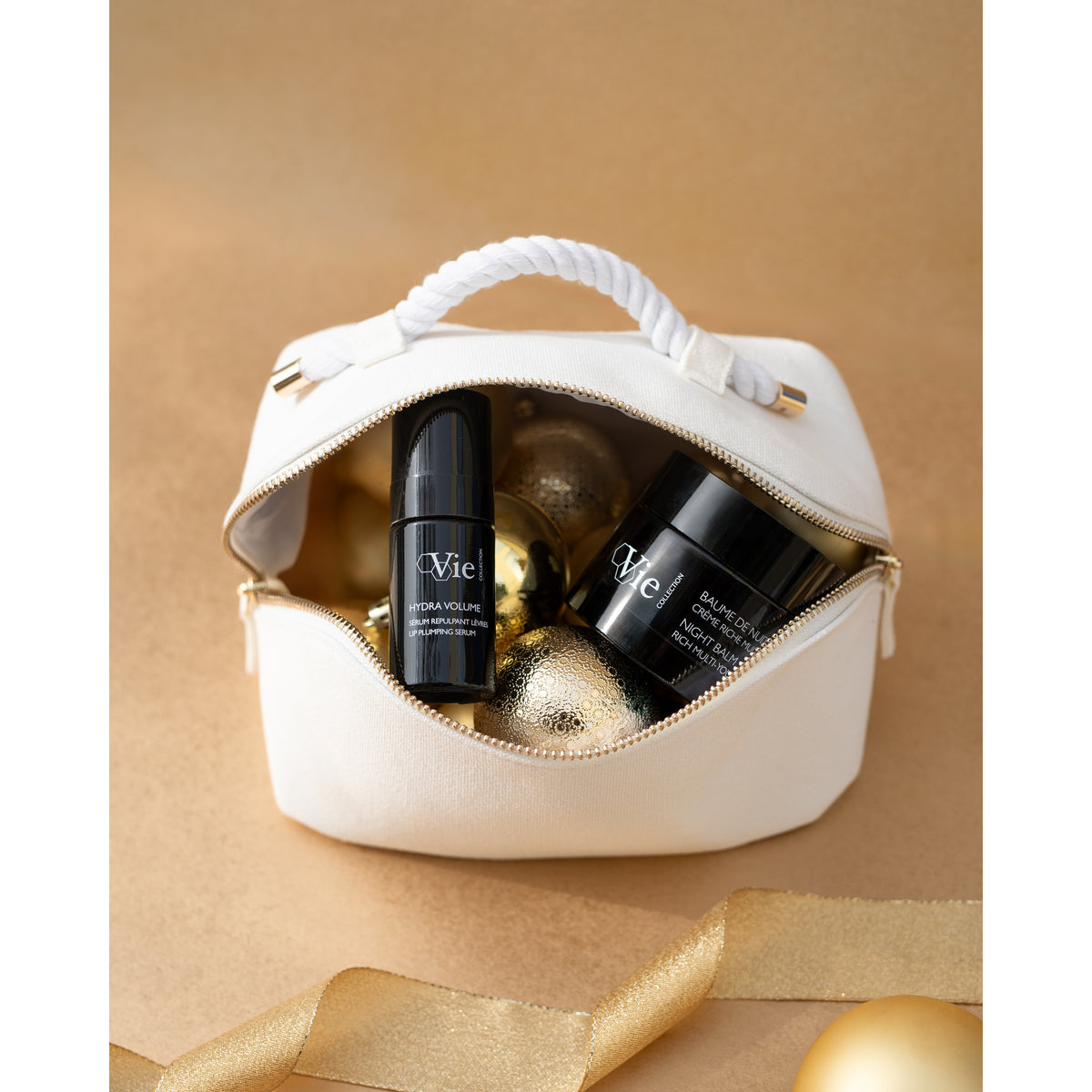 NIGHT BALM cream and Hydra Volume lip serum in a white Vie Collection pouch with gold Christmas decorations