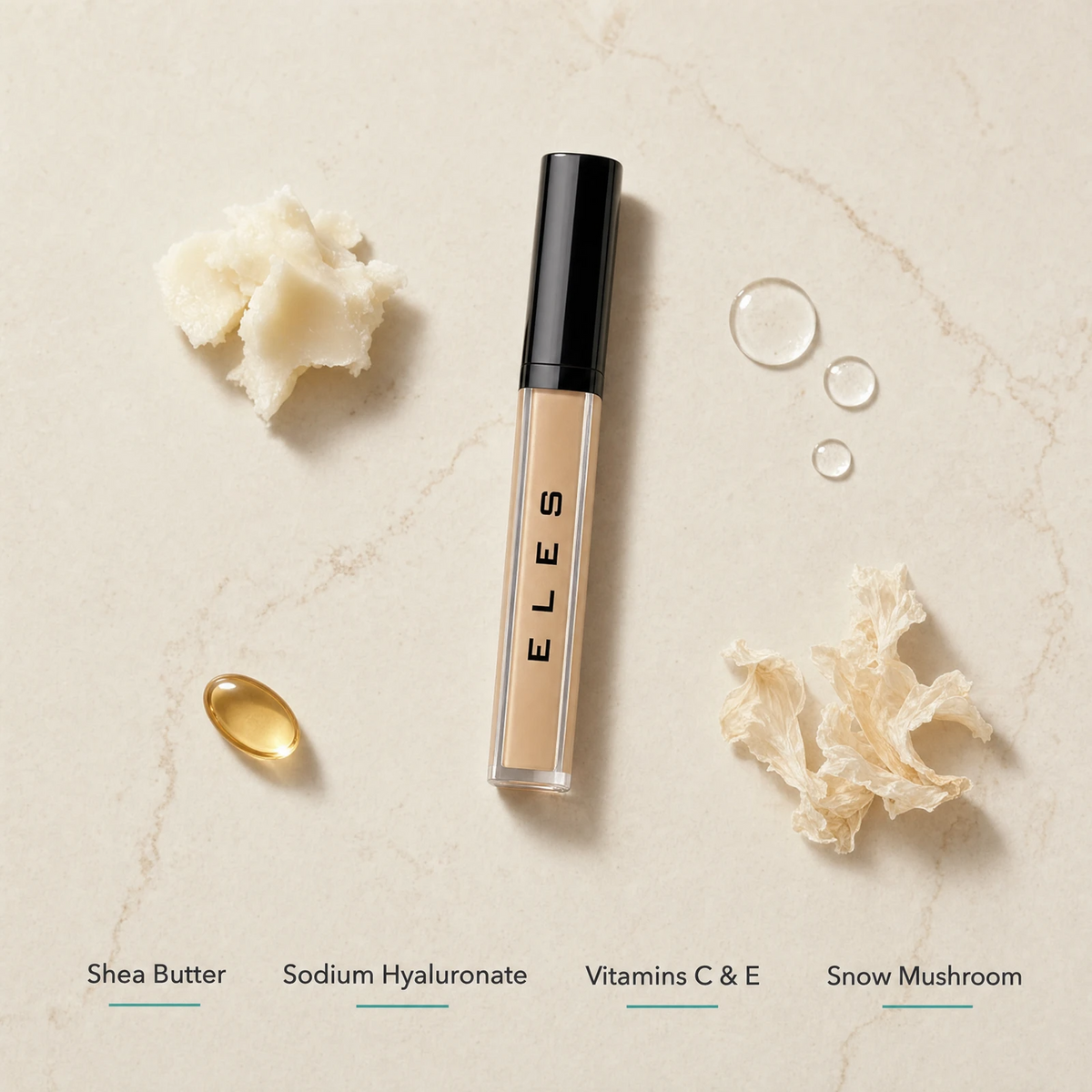 ELES Adjustable Coverage Concealer ingredient flatlay featuring shea butter, sodium hyaluronate, vitamins C and E, and snow mushroom extract on a warm limestone surface