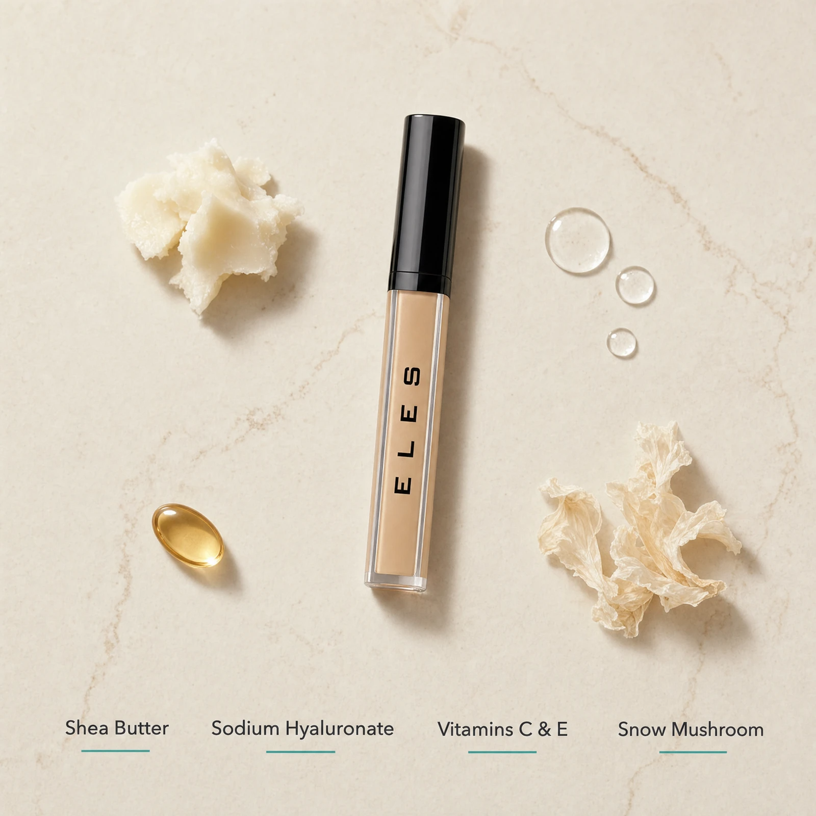 ELES Adjustable Coverage Concealer ingredient flatlay featuring shea butter, sodium hyaluronate, vitamins C and E, and snow mushroom extract on a warm limestone surface
