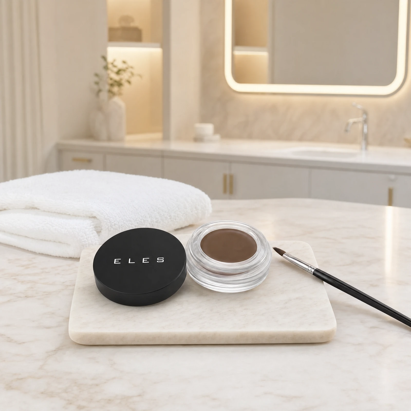 ELES Brow Balm Pomade open jar with lid and angled brow brush on a stone tray on a marble clinic bench inside a premium skin clinic treatment room.