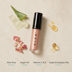 ELES Colour Balm ingredient flatlay featuring aloe vera, argan oil, vitamins C and E, and castor and soybean oils on a warm limestone surface