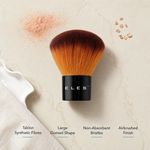 ELES Kabuki Brush top-down feature flatlay showing taklon synthetic fibres, large domed shape, non-absorbent bristles and airbrushed finish with bronzer powder and mica on a warm limestone surface