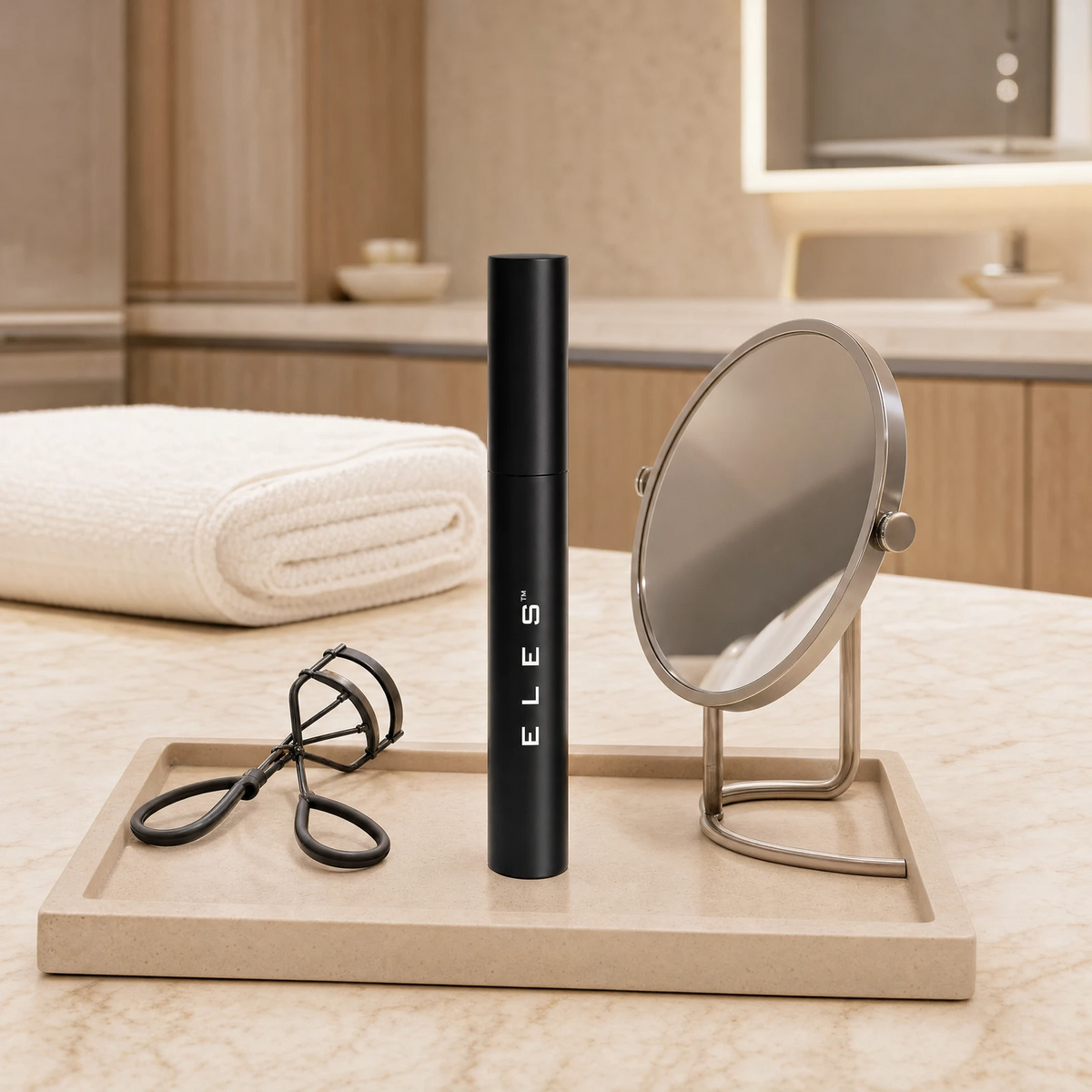 ELES Lash Fortify Mascara Black standing upright on a stone tray with a lash curler and round mirror on a marble clinic bench inside a premium skin clinic treatment room, ideal for professional lash and eye finishing after facial treatments