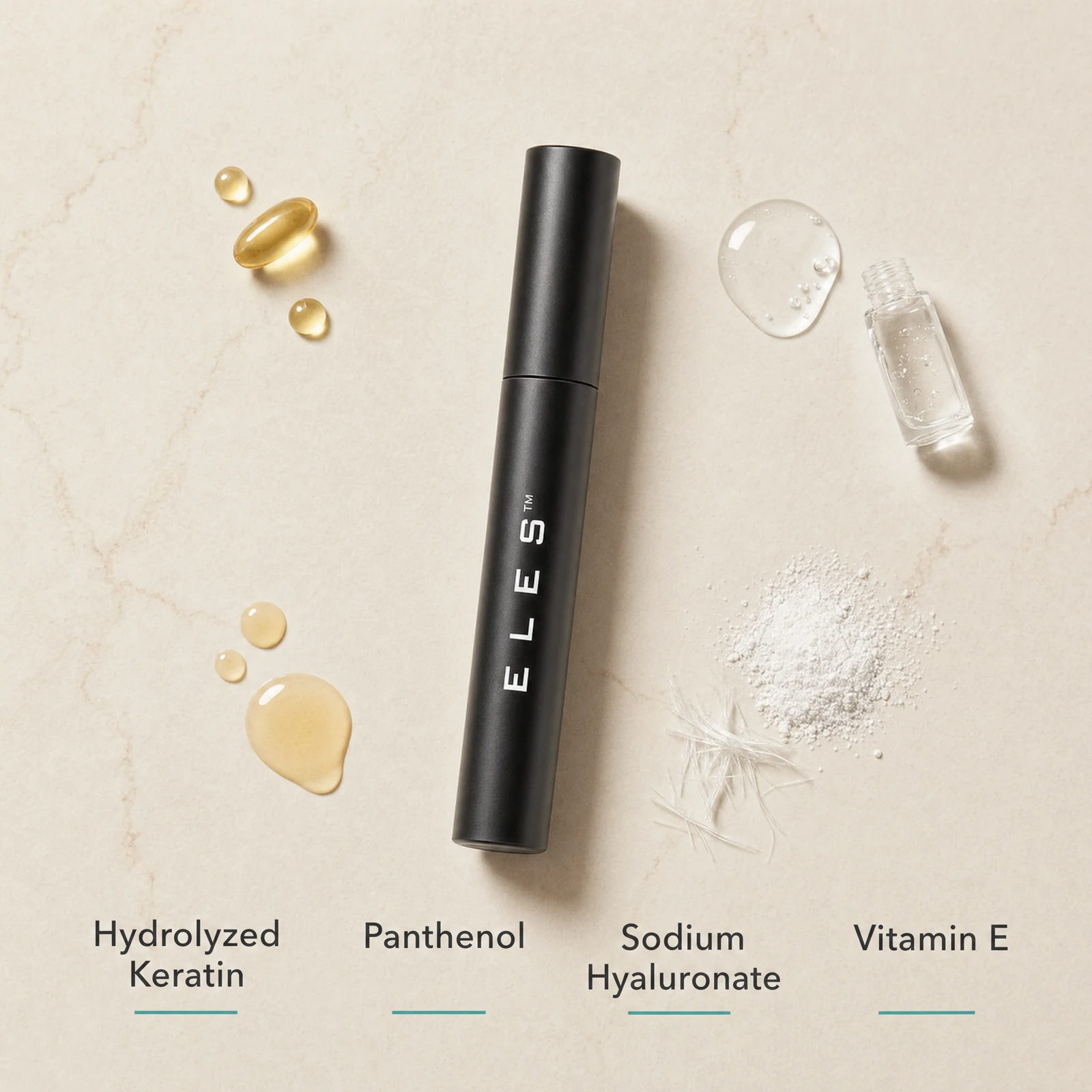 ELES Lash Fortify Mascara Black ingredient flatlay featuring hydrolyzed keratin, panthenol, sodium hyaluronate and vitamin E on a warm limestone surface