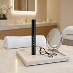 ELES Lash Fortify Waterproof Mascara Black standing upright on a stone tray with a lash curler and round mirror on a marble clinic bench inside a premium skin clinic treatment room, ideal for professional lash and eye finishing after facial treatments
