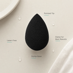 ELES Pro-Blender Sponge feature flatlay showing the matte black teardrop sponge with pointed tip, dome base, foundation swatch and water droplets demonstrating damp-use technique