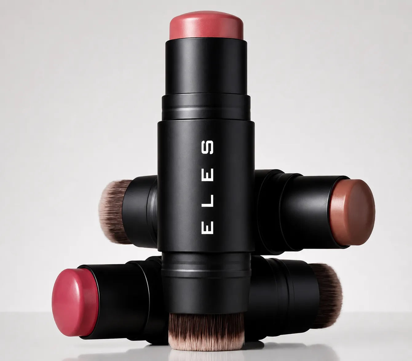 Four ELES Cheek & Lip Cream Blush, arranged in a cross pattern on a light gray background. The brand name 'ELES' is printed vertically on the center stick.