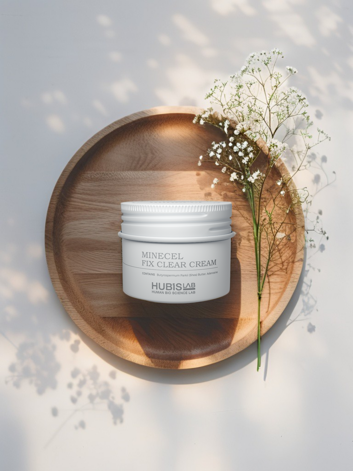 Hubislab Minecel Fix Clear Cream 50ml  for sensitive, dry or post-treatment skin on a wooden plate with flowers on a light background