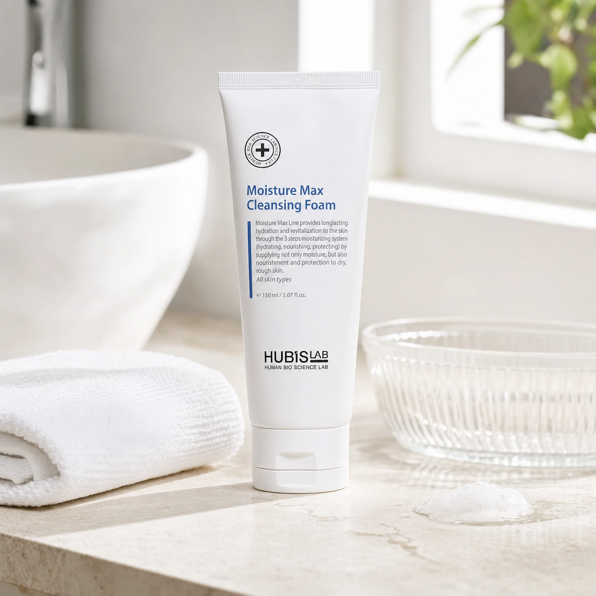 Hubislab Moisture Max Cleansing Foam 150ml displayed on a clean premium bathroom vanity with a soft towel, glass dish and subtle foam cue.