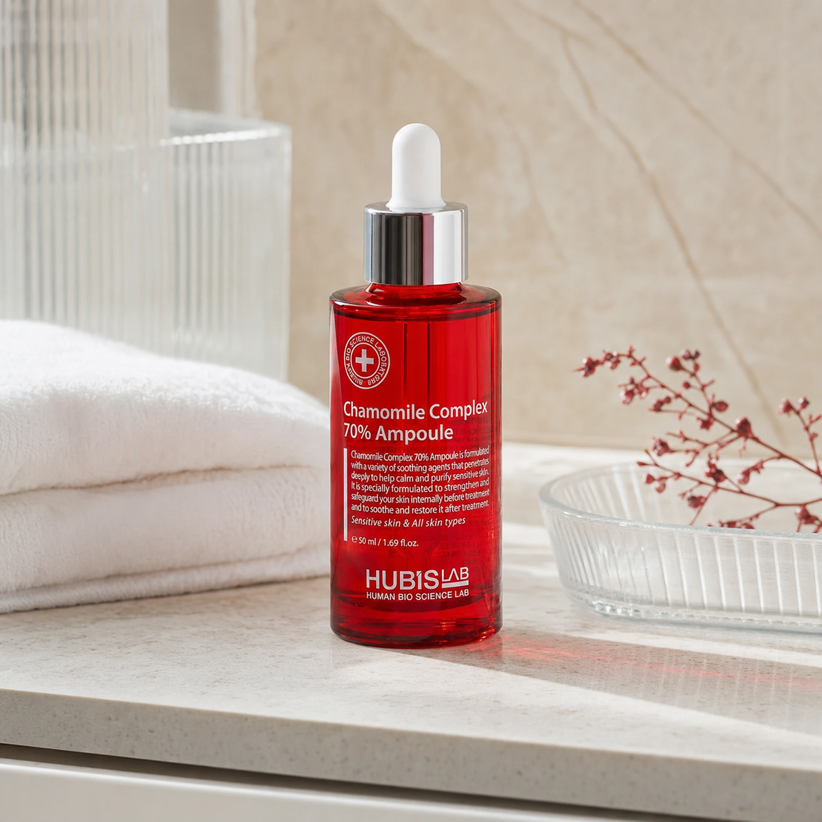 Hubislab Post Rays Chamomile Complex 70% Ampoule 50ml displayed on a clean premium bathroom vanity with a soft towel, glass dish and calming red botanical styling.