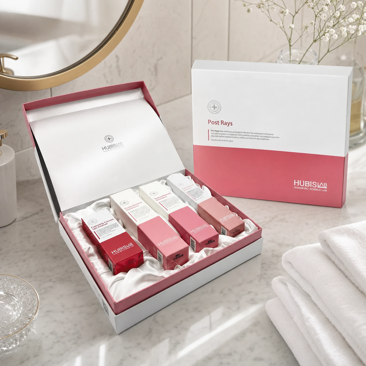 Hubislab Post Rays Deluxe Set displayed in a premium bathroom setting with open presentation box, closed gift box, soft towels and clean clinical-luxury post-care styling.