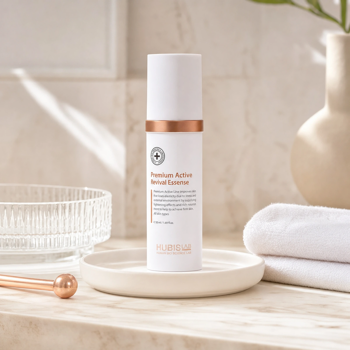 Hubislab Premium Active Revival Essence 50ml displayed on a clean premium bathroom vanity with a soft towel, glass dish and refined copper styling.