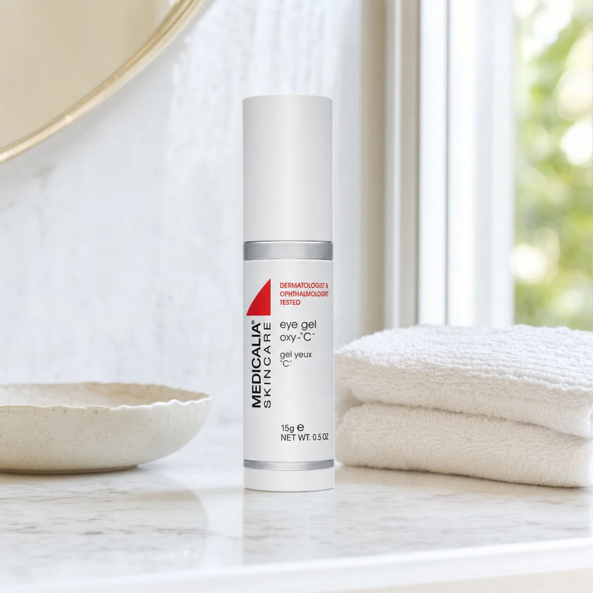 Medicalia Eye Gel Oxy-C 15g on a premium marble bathroom vanity, a refreshing vitamin C eye gel that reduces puffiness, dark circles, and brightens the delicate eye contour.