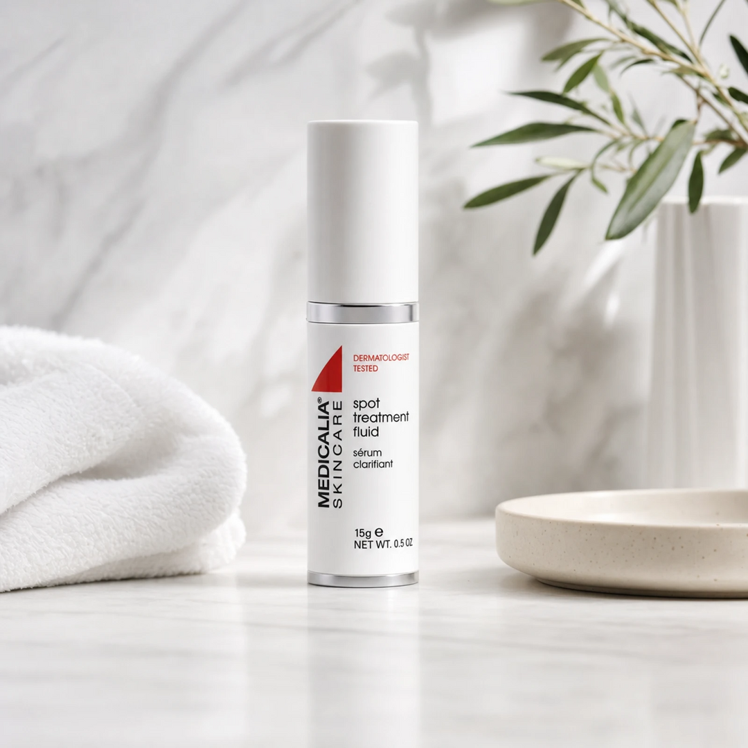 Medicalia Spot Treatment Fluid 15ml on a premium marble bathroom vanity, a fast-acting professional-grade blemish treatment with salicylic and glycolic acids for acne-prone skin.