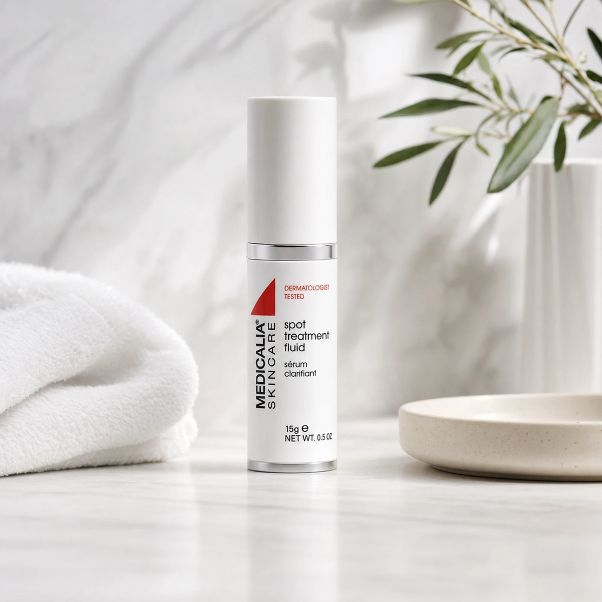Medicalia Spot Treatment Fluid 15ml on a premium marble bathroom vanity, a fast-acting professional-grade blemish treatment with salicylic and glycolic acids for acne-prone skin.