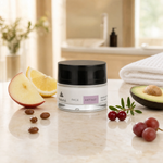 Naturys Anti-Age Double Action Peel Mask 30ml on a warm cream marble spa surface with an apple slice, lemon wedge, jojoba beads, avocado half, cranberry sprig, small grape cluster, and a folded white waffle spa cloth in a softly lit luxury spa treatment room