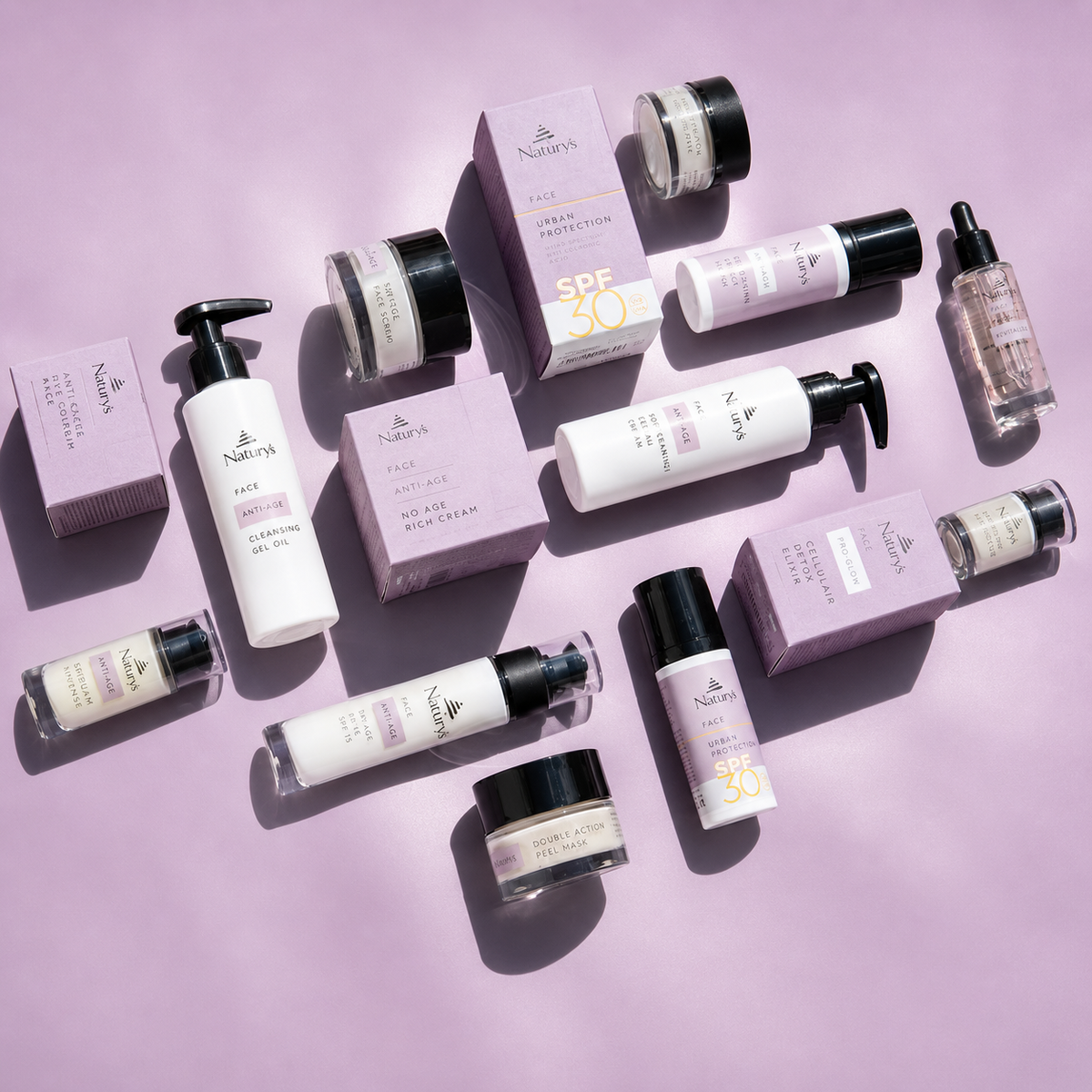 Naturys Face Anti-Age skincare range flat lay featuring SPF 50 serum cleanser cream and treatment products on lavender background for mature and dehydrated skin