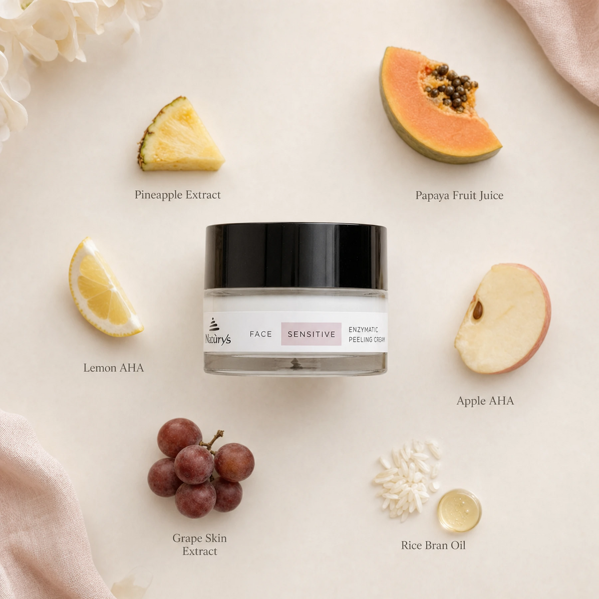 Naturys Sensitive Enzymatic Peeling Cream 50ml ingredient flatlay on warm blush surface with labelled ingredients: Pineapple Extract, Papaya Fruit Juice, Lemon AHA, Apple AHA, Grape Skin Extract, and Rice Bran Oil