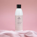 A bottle of Naturys Silky Skin Enzymatic Peel Gel on a pink background.