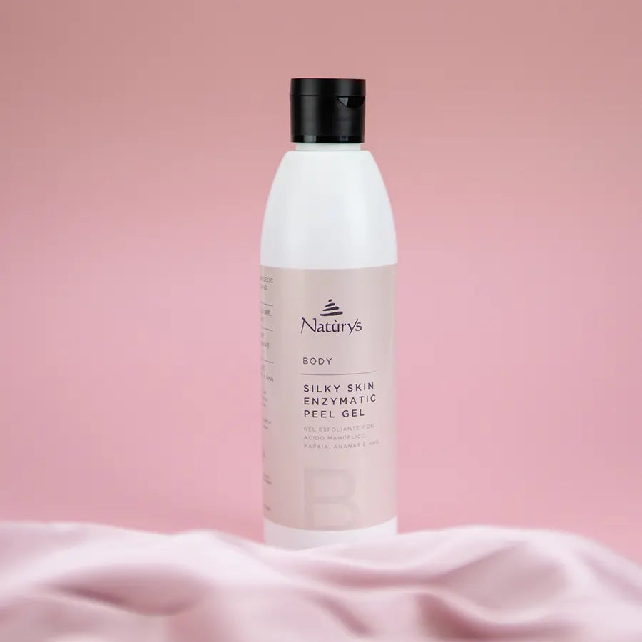 A bottle of Naturys Silky Skin Enzymatic Peel Gel on a pink background.