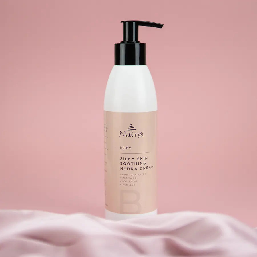 Naturys Silky Skin Soothing Hydra Cream 250ml on a pink satin sheet with pink background.