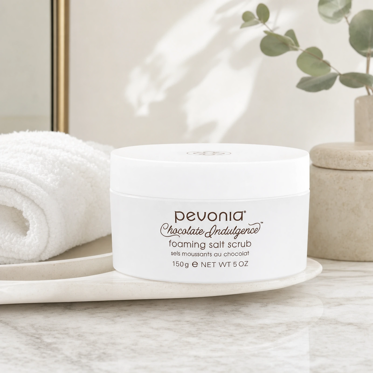Pevonia Chocolate Indulgence Foaming Salt Scrub 150ml on a luxury bathroom vanity for smoother, softer and more radiant face and body skin