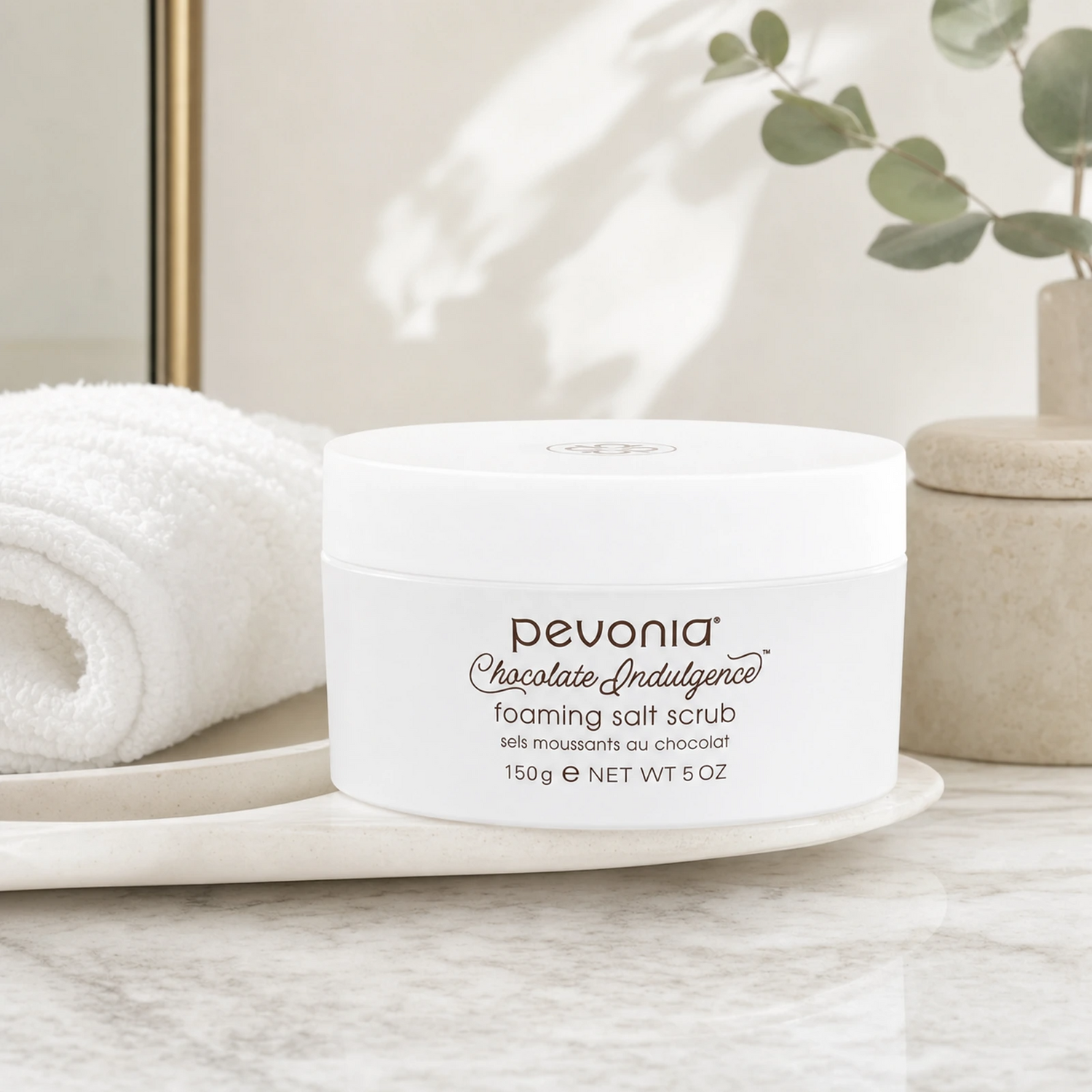 Pevonia Chocolate Indulgence Foaming Salt Scrub 150ml on a luxury bathroom vanity for smoother, softer and more radiant face and body skin