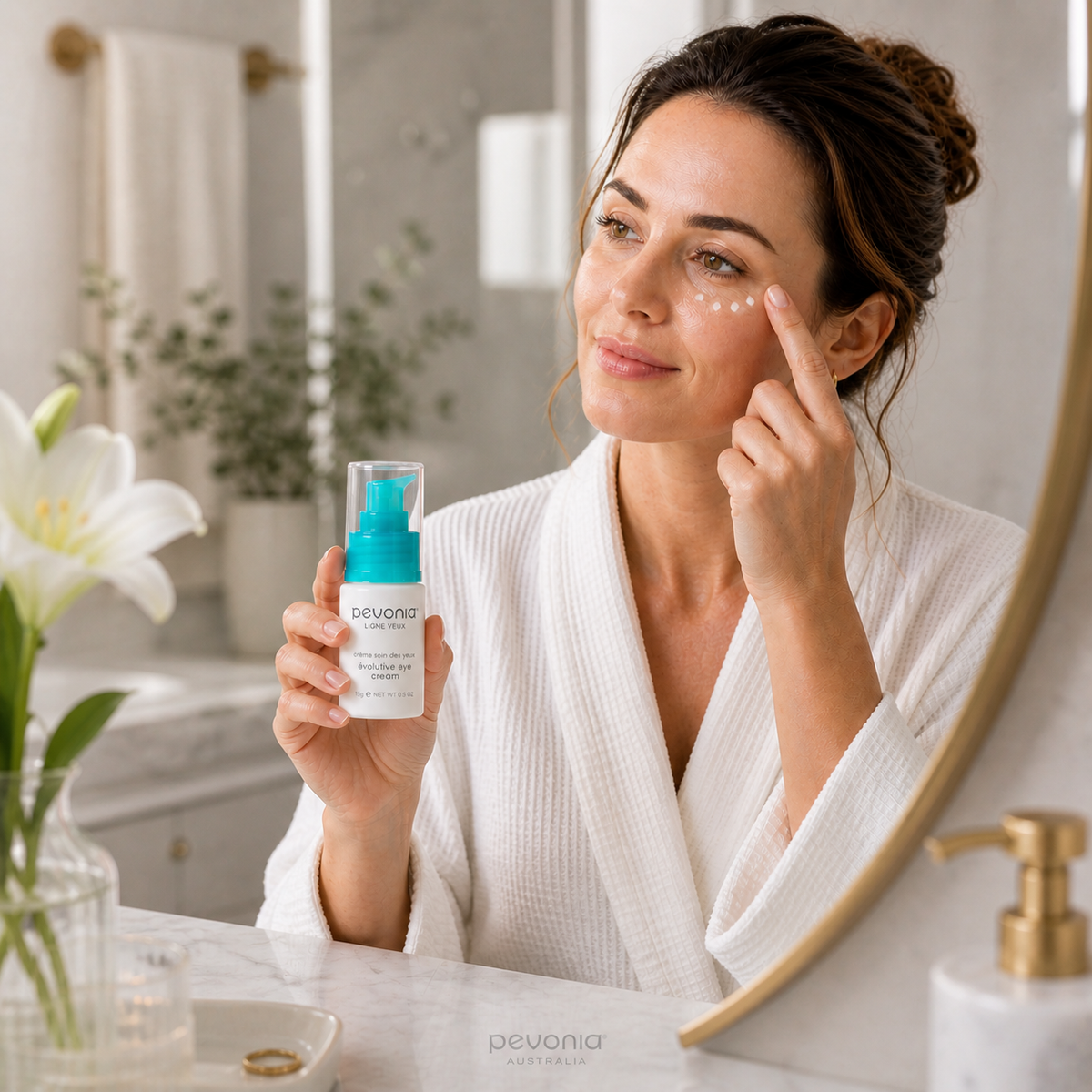 Woman applying Pevonia Evolutive Eye Cream in bathroom skincare routine under eye treatment anti ageing eye cream Australia