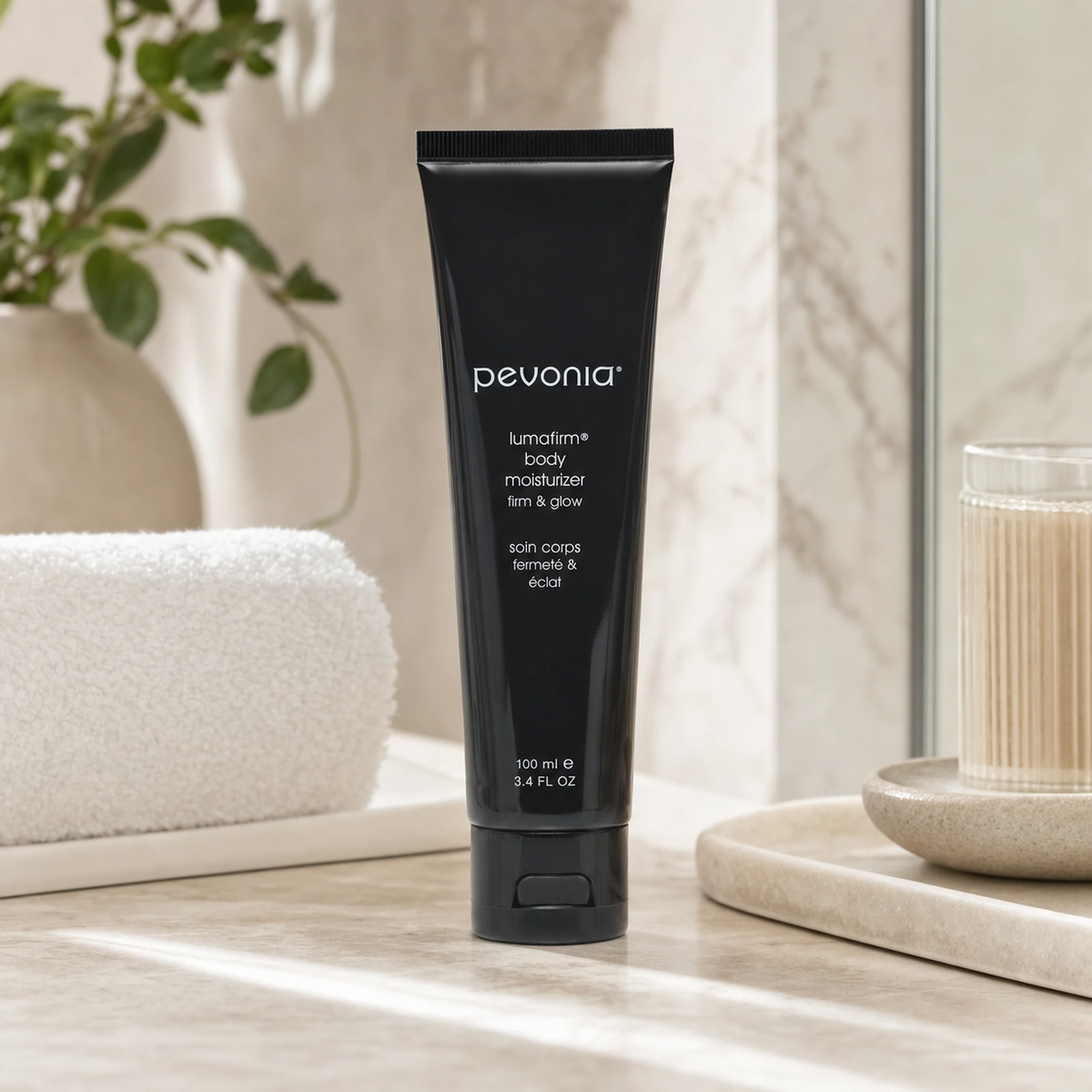 Pevonia Lumafirm Body Moisturizer 100ml on a luxury bathroom vanity for firmer, smoother and brighter body skin