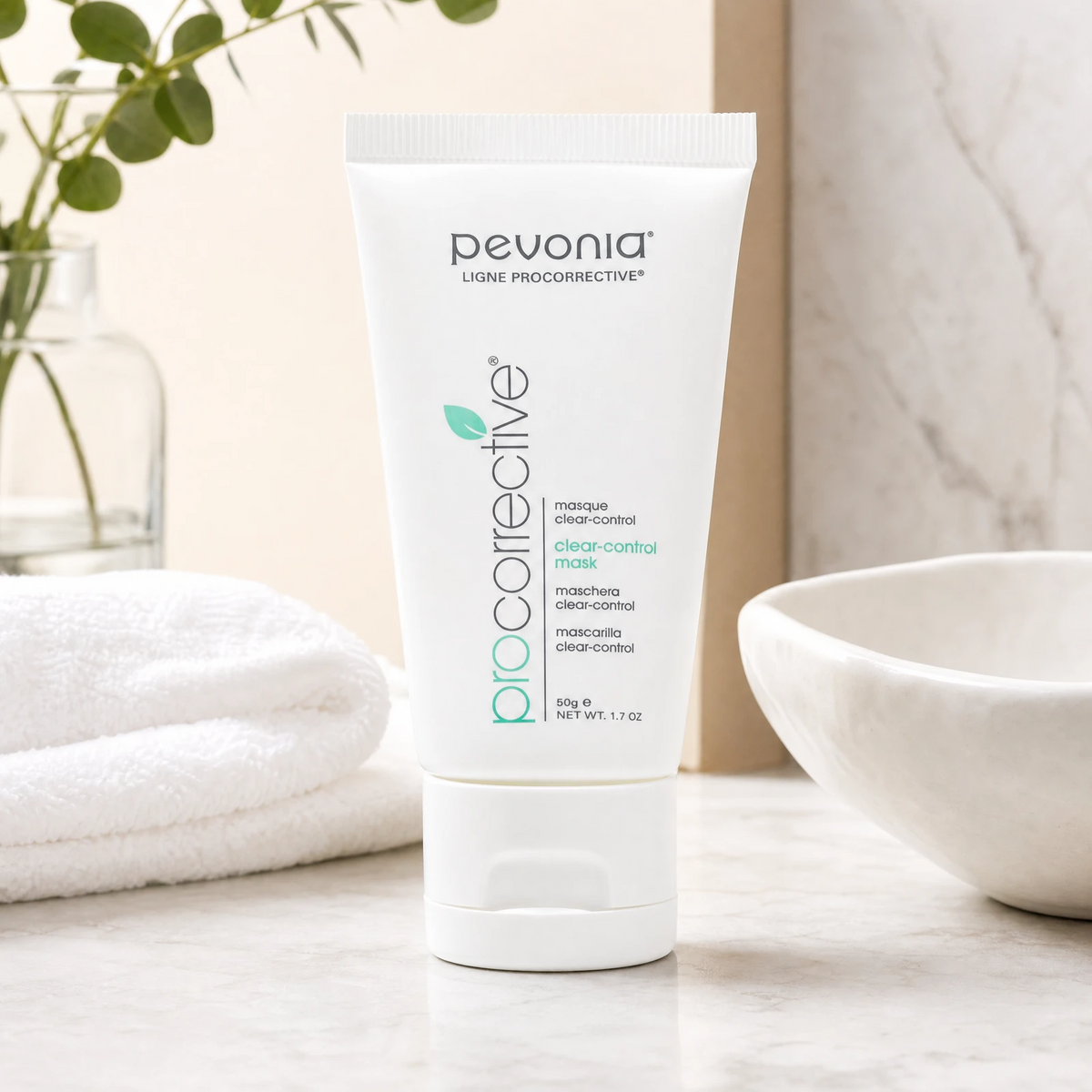 Pevonia ProCorrective Clear-Control Mask 50ml white tube styled on a marble vanity with white towels and greenery for Beauty Collective consumer retail.