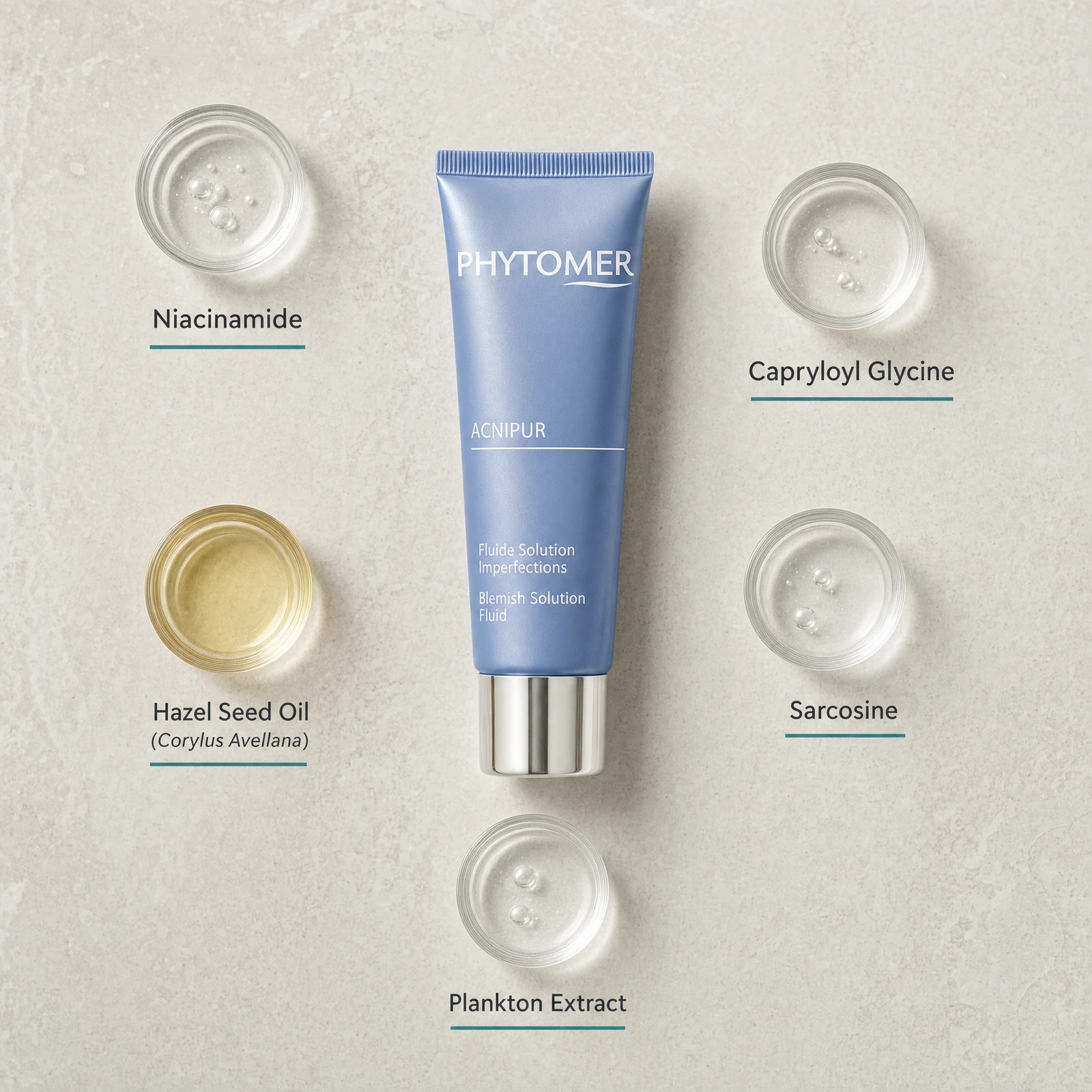 Phytomer Acnipur Blemish Solution Fluid 50ml flatlay on limestone surface with Niacinamide, Capryloyl Glycine, Hazel Seed Oil, Sarcosine, and Plankton Extract